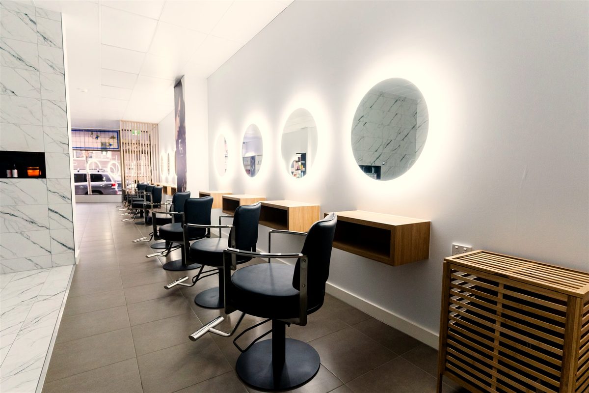 Row of backlit round mirrors down the salon at Fallachi Hair Berwick